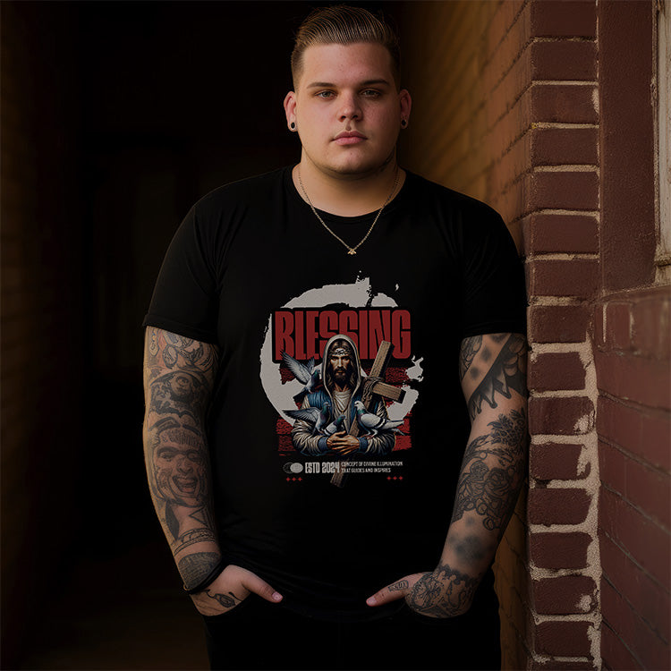 Man wearing a black t-shirt with a graphic design leaning against a brick wall.
