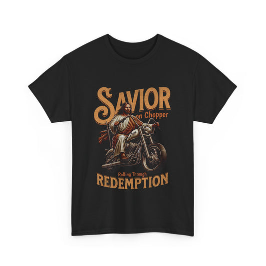 A black streetwear t-shirt featuring a detailed vintage-style graphic of Jesus riding a classic chopper motorcycle. The word 'SAVIOR' is printed in large, arched tan letters at the top, with 'on Chopper' and 'Rolling Through REDEMPTION' written in smaller text surrounding the central image.