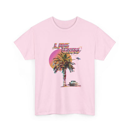 A light pink t-shirt with a retro Las Vegas glitch graphic featuring a palm tree, a sunset, and UFOs over a desert landscape.