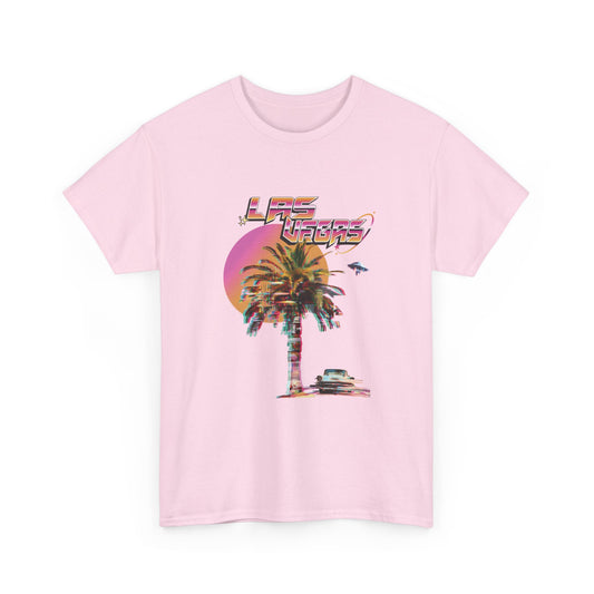 A light pink t-shirt with a retro Las Vegas glitch graphic featuring a palm tree, a sunset, and UFOs over a desert landscape.