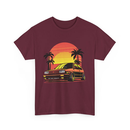 A maroon t-shirt featuring a graphic print of a classic car drifting under a sunset with palm trees.