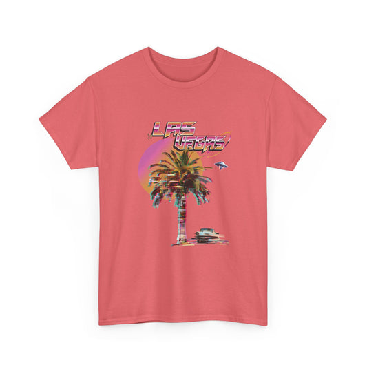 A coral t-shirt with a retro Las Vegas glitch graphic featuring a palm tree, a sunset, and UFOs over a desert landscape.